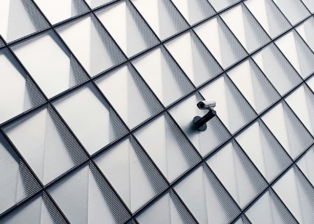a security camera on the wall of a minimalist modernist building